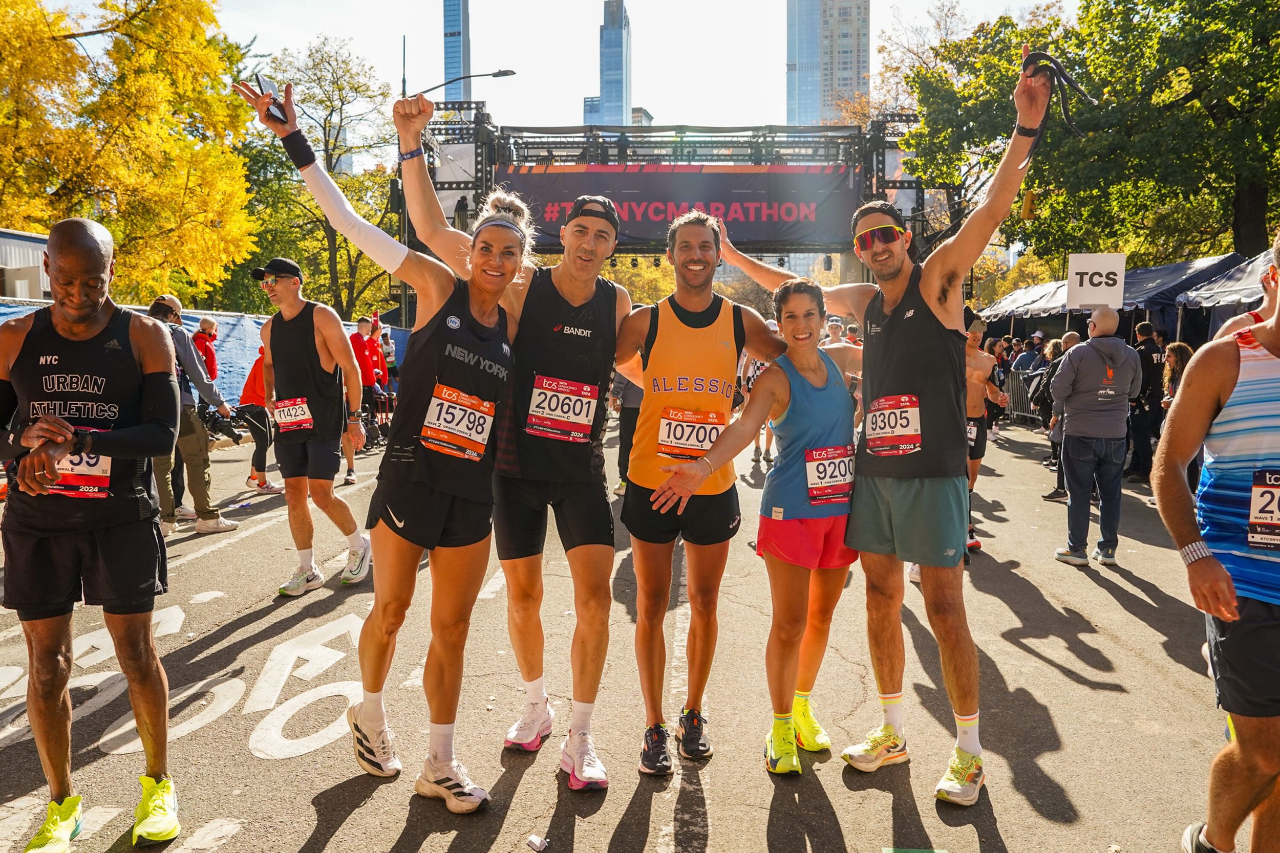 Runners smiling and posing at the TCS NYC Marathon.