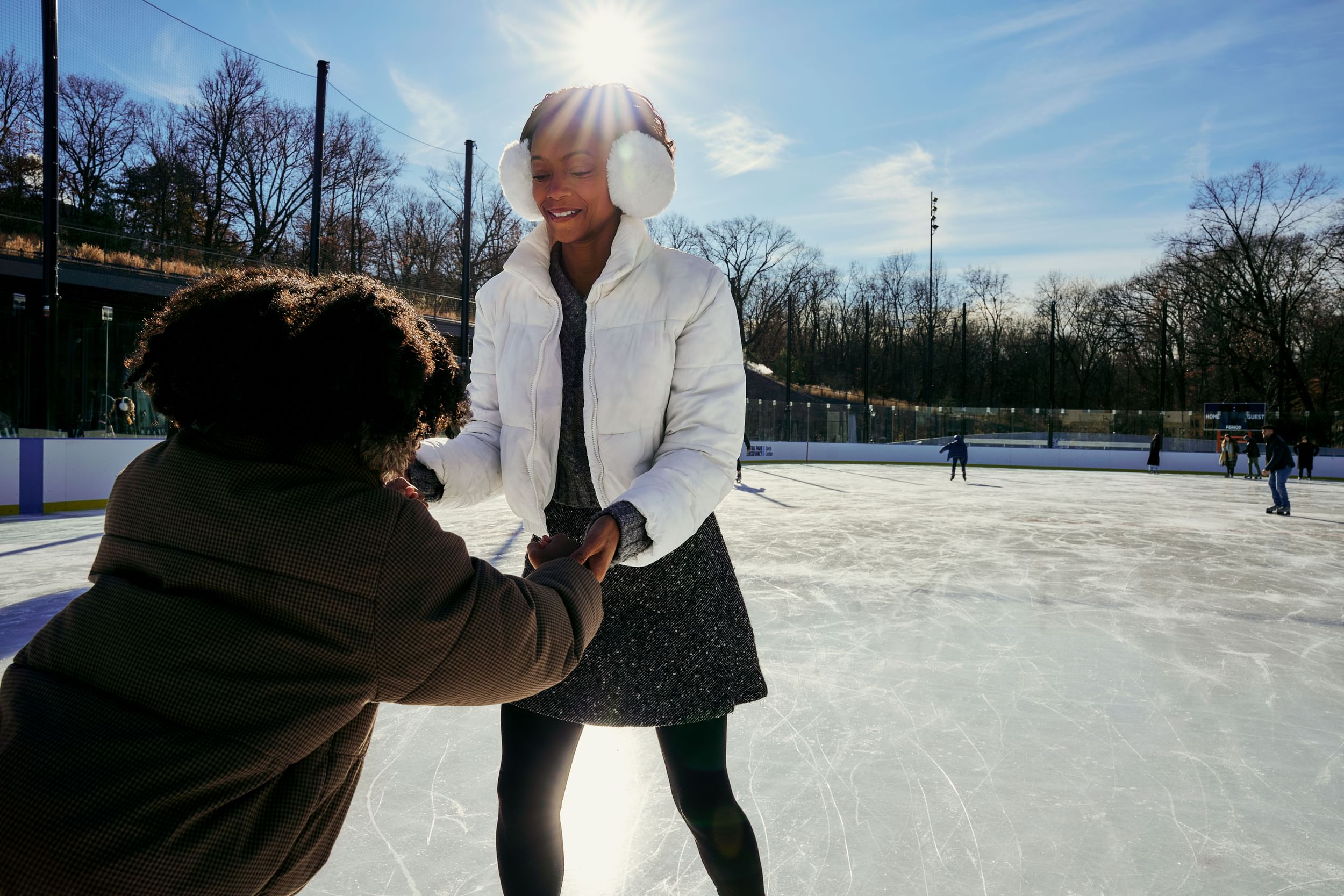 Smiling ice skaters on the Davis Center ice rink in Harlem, NYC