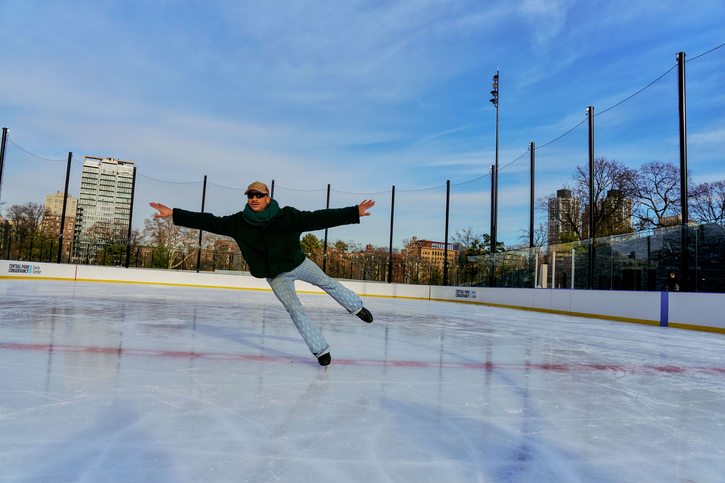 Ice skater effortlessly gliding on one foot at the Gottesman Ice Rink in Harlem, NYC