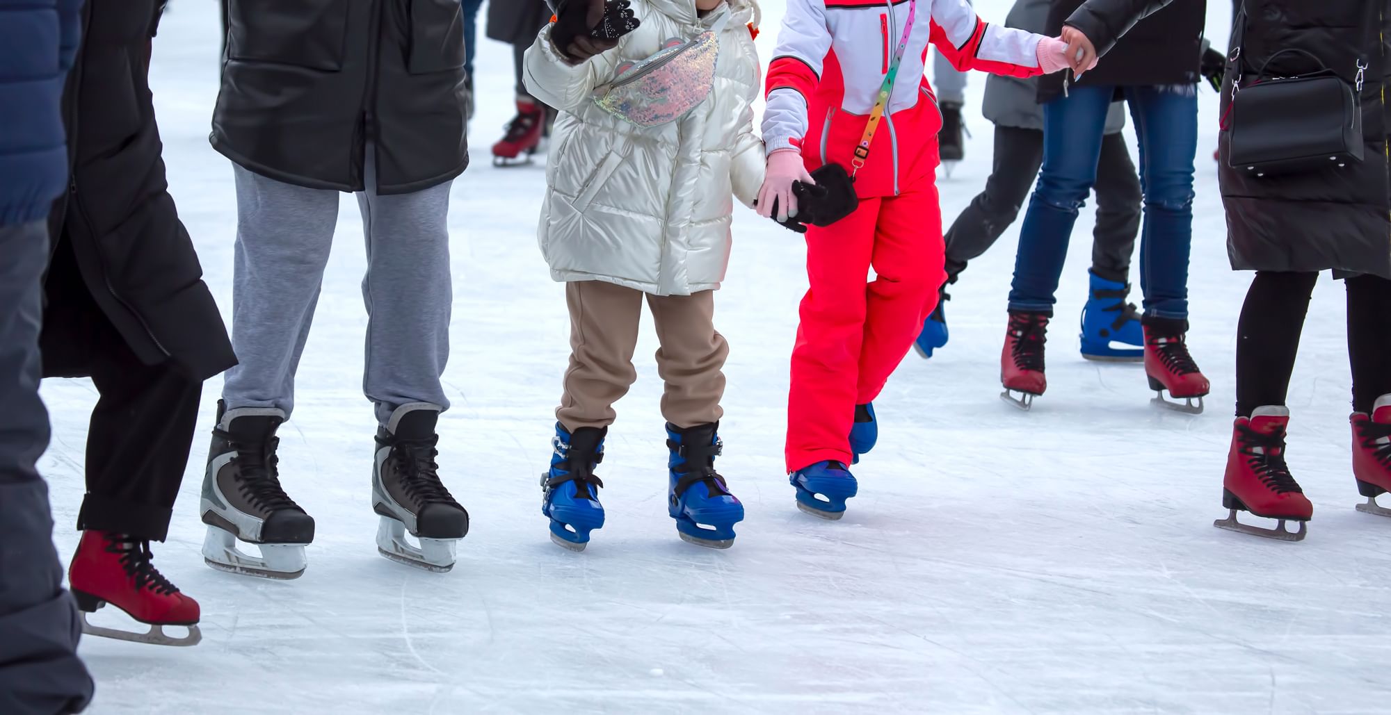 A family holding hands and skating together on smooth ice