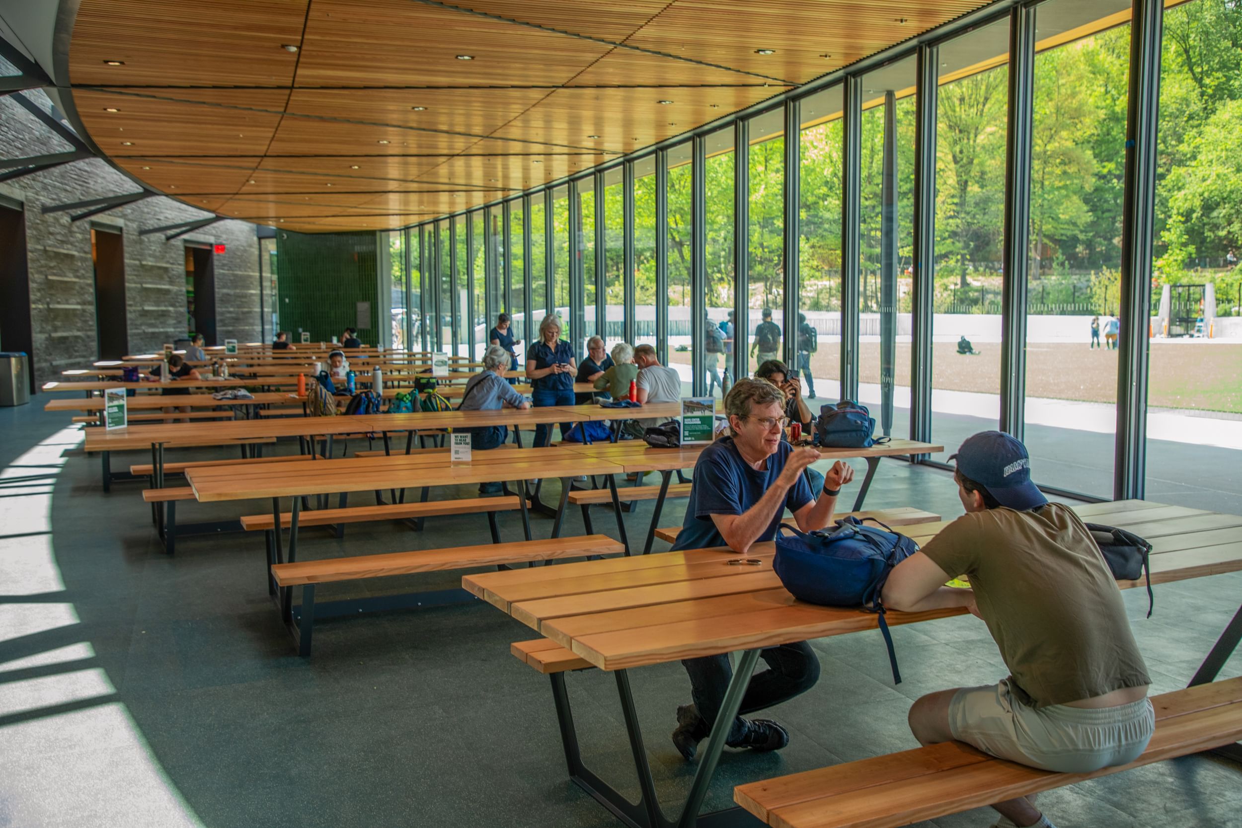 Inside shot of the Davis Center at the Harlem Meer, people sitting at tables