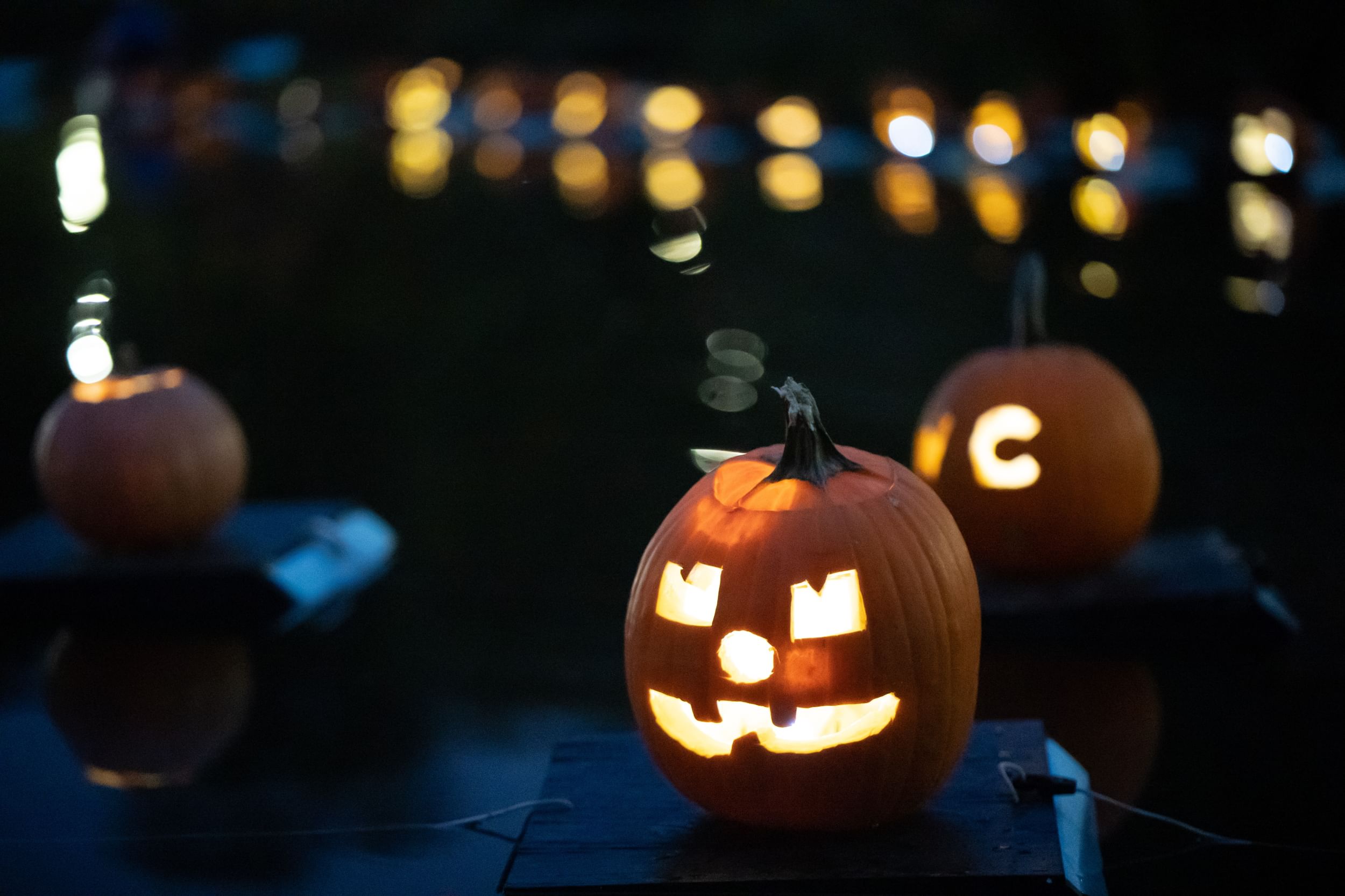 Pumpkins, lit from within, floating on the Harlem Meer at night
