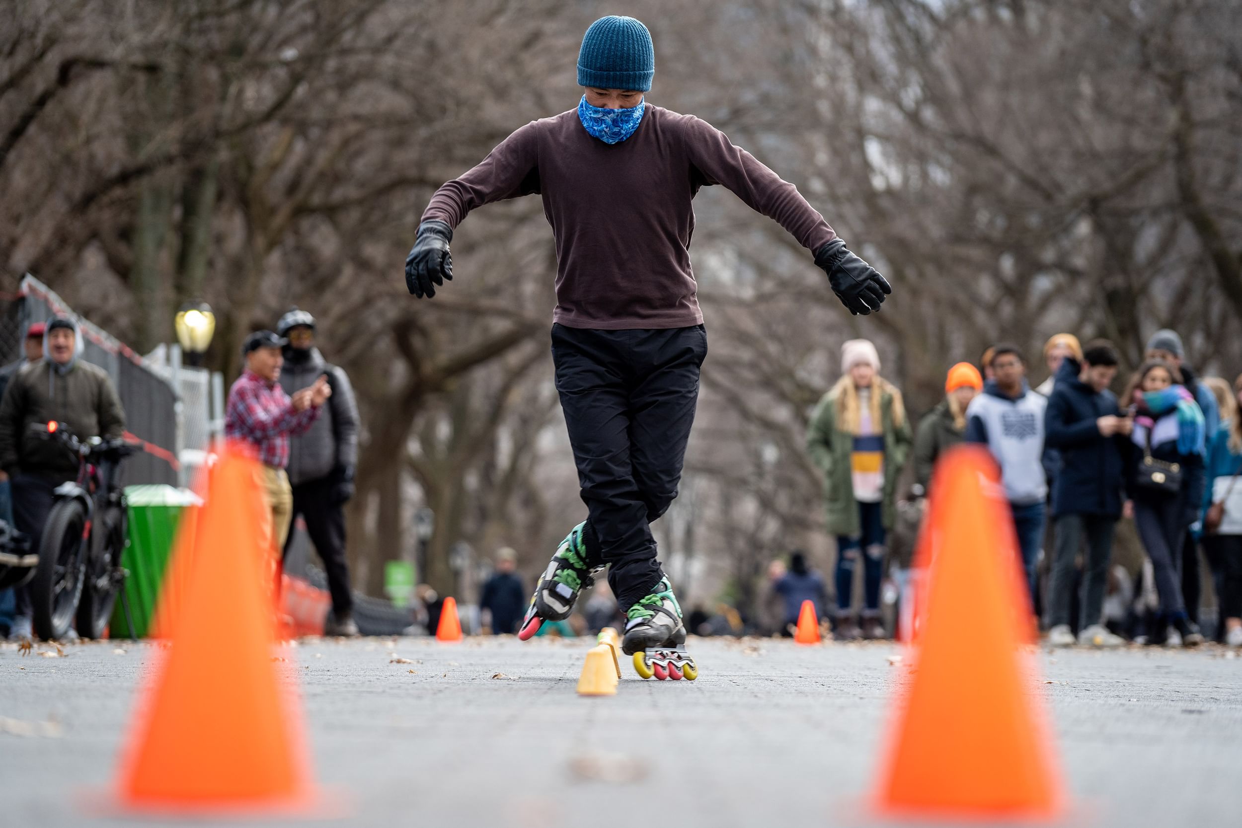 A rollerblader manuevering through a chicane of orange cones to the delight of onlookers
