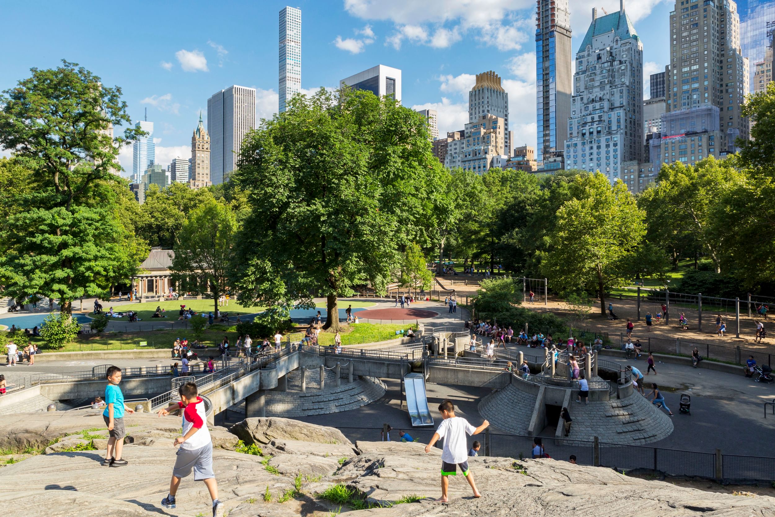 Children at play on the rocks at one end of the playground, with the skyline as a backdrop